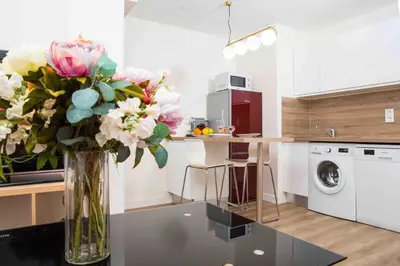 a vase of flowers on a table in a kitchen at Perle de Nice - 50 mètres de la plage, Clim, Wifi in Nice
