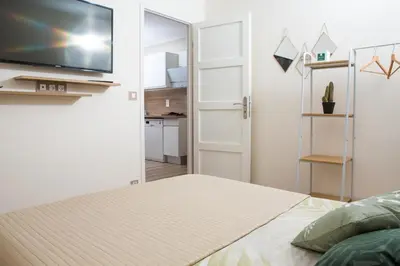 a bedroom with a bed and a flat screen tv at Perle de Nice - 50 mètres de la plage, Clim, Wifi in Nice