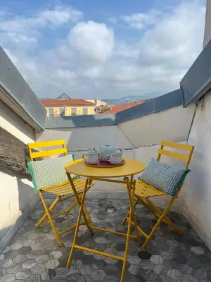 a yellow table and two chairs on a balcony at 1 bedroom, Best location in Nice in Nice