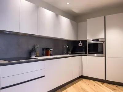 a kitchen with white cabinets and stainless steel appliances at Appartement Niçois - 3 Pièces au Centre in Nice