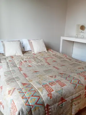 a large bed with a brown and white quilt on it at Family villa 10 minutes from Nice beaches in Nice
