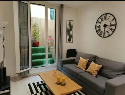a living room with a couch and a clock on the wall at Studio in the heart of Nice in Nice