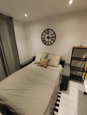 a bedroom with a bed with a clock on the wall at Studio in the heart of Nice in Nice