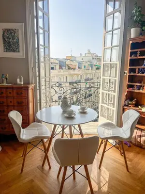 a table and chairs in a room with a window at 5 sky miniPenthouse in Nice