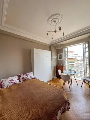 a bedroom with a bed and a table and a window at 5 sky miniPenthouse in Nice