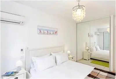 a white bedroom with a mirror and a bed at 2 pièces centre ville-Balcon in Nice