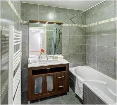 a bathroom with a tub and a sink and a bath tub at 2 pièces centre ville-Balcon in Nice