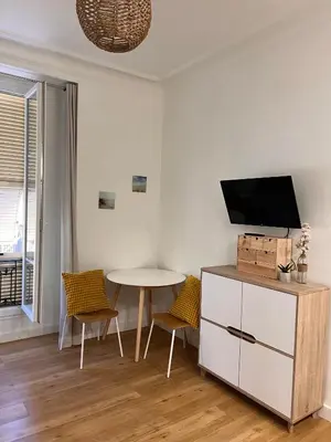 a living room with a table and a tv at Simply the best! All you need! in Nice