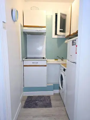 a small kitchen with a stove and a dishwasher at 2P cosy à 2 min de la mer, Tram aéroport & centre in Nice
