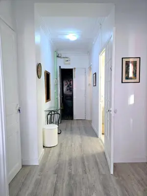 an empty hallway with white walls and wood floors at 2P cosy à 2 min de la mer, Tram aéroport & centre in Nice