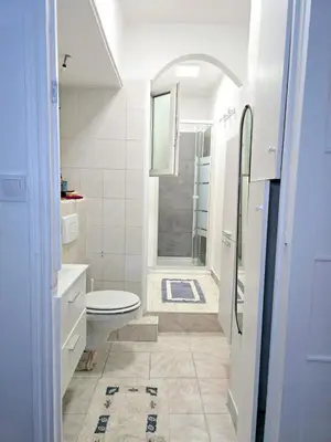 a white bathroom with a toilet and a shower at 2P cosy à 2 min de la mer, Tram aéroport & centre in Nice