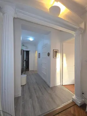 a hallway with white columns and a white door at 2P cosy à 2 min de la mer, Tram aéroport & centre in Nice