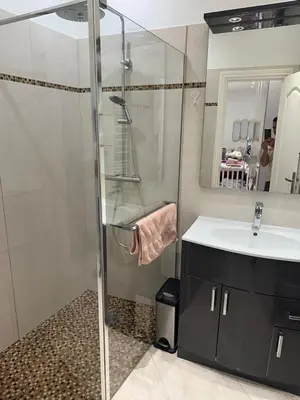 a bathroom with a glass shower and a sink at Cosmina Residence in Nice