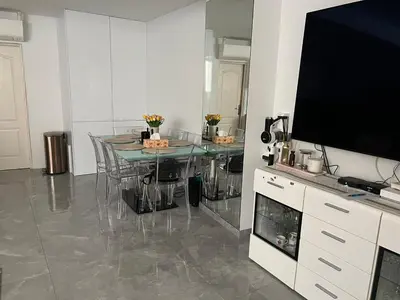 a dining room with a table and a large television at Cosmina Residence in Nice