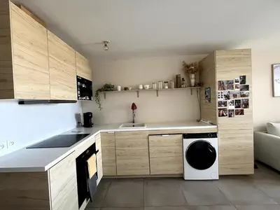 a kitchen with a sink and a washing machine at Appartement calme vue mer in Saint-Laurent-du-Var