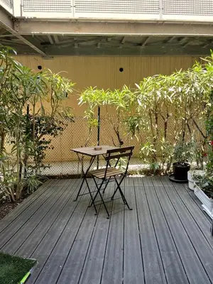 a table and a chair on a wooden deck at Appartement calme vue mer in Saint-Laurent-du-Var
