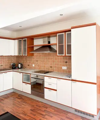 a kitchen with white cabinets and wood floors at Hyper-centre, Air-conditioned apartment with balcony in Nice