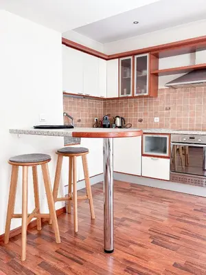 a kitchen with white cabinets and a counter with stools at Hyper-centre, Air-conditioned apartment with balcony in Nice