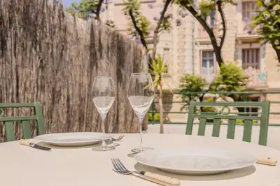 a table with two wine glasses and plates on it at Nice, Studio Grande Terrasse à 2 pas de la promenade in Nice