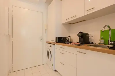 a white kitchen with a sink and a washing machine at Nice, Studio Grande Terrasse à 2 pas de la promenade in Nice