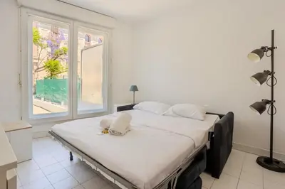 a large bed in a room with a large window at Nice, Studio Grande Terrasse à 2 pas de la promenade in Nice