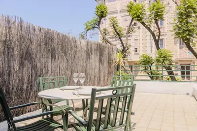 a table and chairs on a patio with a fence at Nice, Studio Grande Terrasse à 2 pas de la promenade in Nice