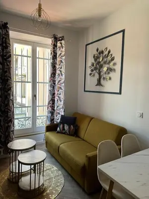 a living room with a couch and two tables at MOON 21 in Nice