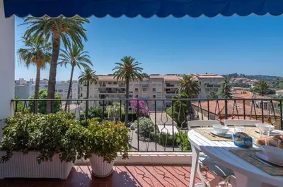 a balcony with a table and a view of a city at Beaulieu Garden Apartment in Beaulieu-sur-Mer