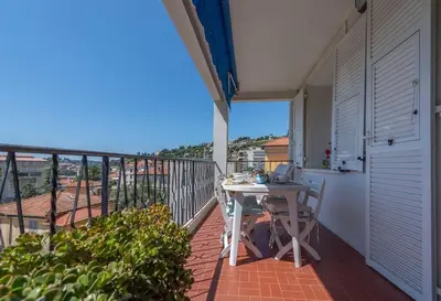 a balcony with a table and chairs on a balcony at Beaulieu Garden Apartment in Beaulieu-sur-Mer