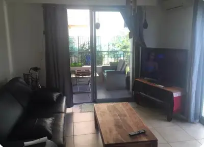 a living room with a couch and a coffee table at Magnifique studio avec terrasse et jardin in Nice