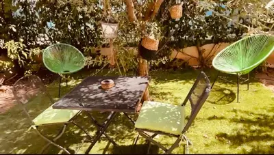 a table and chairs in a yard with a table and two chairs at Magnifique studio avec terrasse et jardin in Nice