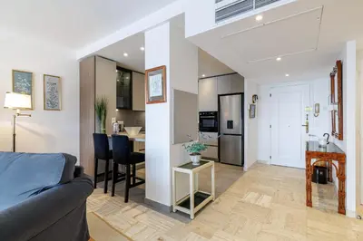 a living room with a couch and a kitchen at MY CASA - VILLEFRANCHE RESTANQUES - Panoramic sea view 2 bedrooms Swimming pool in Villefranche-sur-Mer