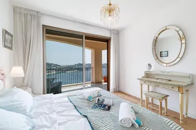 a bedroom with a bed and a desk and a mirror at MY CASA - VILLEFRANCHE RESTANQUES - Panoramic sea view 2 bedrooms Swimming pool in Villefranche-sur-Mer
