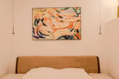 a painting hanging above a bed in a bedroom at Paganini 3bd Apartment in Nice