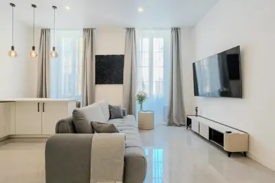 a living room with a couch and a tv at Paganini 3bd Apartment in Nice