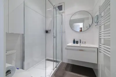 a white bathroom with a shower and a sink at Capitol Close To The Beach - Happy Rentals in Nice