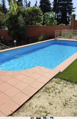 a swimming pool with a tiled walkway around it at Cosy studio piscine eze bord de mer in Èze