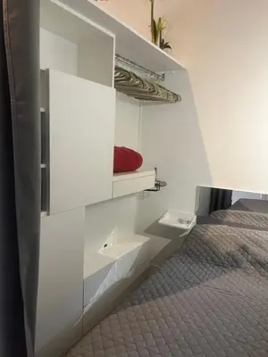a white bedroom with a bed and a red pillow at Cosy studio piscine eze bord de mer in Èze