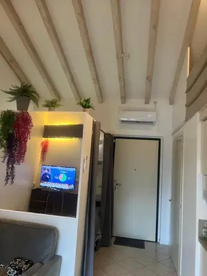a room with a white refrigerator and a door at Cosy studio piscine eze bord de mer in Èze