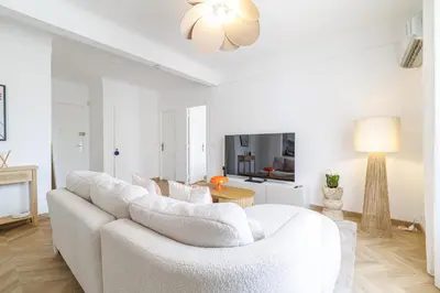 a white living room with a white couch and a table at Wide & Cozy 1 Bdr Downtown in Nice