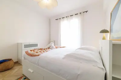 a white bedroom with a large bed and a window at Wide & Cozy 1 Bdr Downtown in Nice