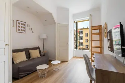 a living room with a couch and a table at Studio cosy dans une belle copropriete classee in Nice