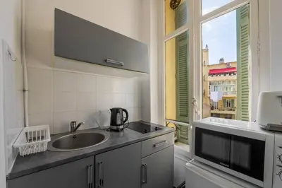 a kitchen with a sink and a large window at Studio cosy dans une belle copropriete classee in Nice