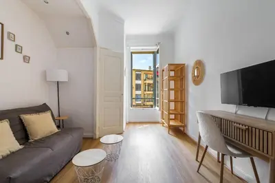 a living room with a couch and a flat screen tv at Studio cosy dans une belle copropriete classee in Nice
