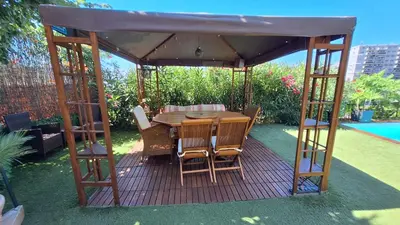 a wooden table and chairs under a gazebo at Villa in Nice French Riviera in Nice