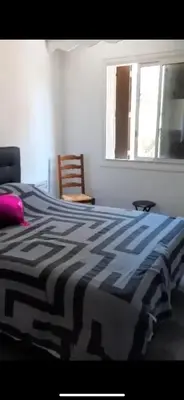a black and white bed in a bedroom with a window at Endroit calme in Nice