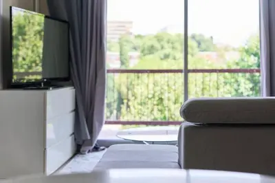 a living room with a couch and a large window at Appartement 3 pièces Nice-Ouest in Nice