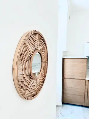 a wicker mirror hanging on a wall in a kitchen at Nest In Nice in Nice