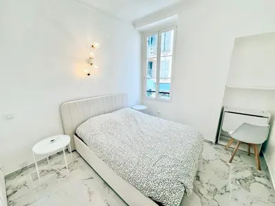 a white bedroom with a bed and a window at Nest In Nice in Nice