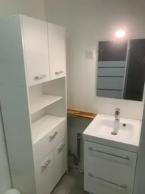 a white bathroom with a sink and a mirror at studio 30m2 in Nice